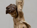 a statue of a cupid holding a candle on a table