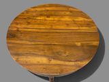 a round table with a wooden top on a gray surface
