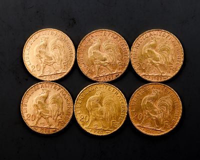 six souverains d'or de tailles et de formes différentes posés sur une surface noire