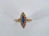 a close up of a gold ring with a blue stone