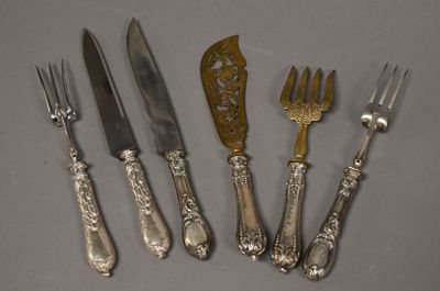 six fourchettes et couteaux en métal argenté sont alignés sur une table