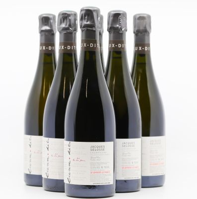 quatre bouteilles de vin sont alignées sur une surface blanche