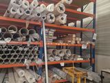 many rolls of fabric on the shelves in the warehouse
