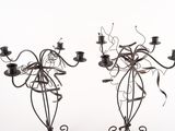 two metal candelabs with candles on them on a table