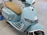 un scooter bleu garé dans un garage, avec d'autres scooters en arrière-plan