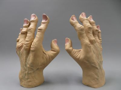 pair of hands made out of clay on a gray background