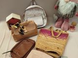 many bags and purses on a table next to a stuffed gnome