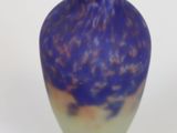 a blue and purple vase sitting on a white surface