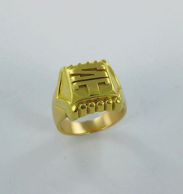 gros plan d'une bague en or sur une surface blanche