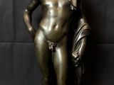 bronze statue of a boy holding a bag and a book
