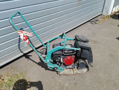 a small lawn mower sitting on the ground next to a garage