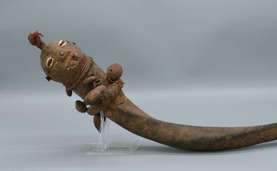 une grande corne surmontée d'un petit animal
