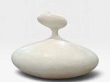 un vase blanc posé sur une surface blanche
