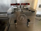 two deep fryers sitting on a counter in a kitchen