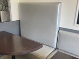 une table avec deux chaises et un banc dans un coin de la pièce