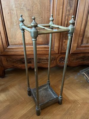 a metal stand on the floor in front of a wooden cabinet