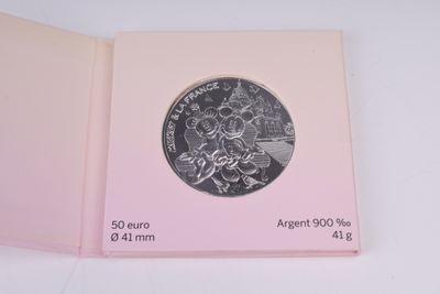 une image représentant un livre rose contenant une pièce d'argent
