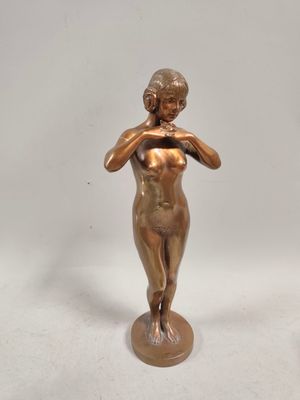 statue en bronze représentant une femme portant ses mains à son visage