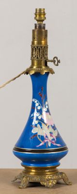 un vase bleu muni d'une anse dorée, posé sur une table en bois