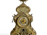 une horloge en or surmontée d'une couronne