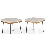 a pair of stools with wooden legs and a beige seat