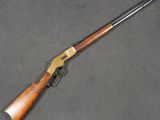 un fusil avec une crosse en bois posé sur une surface grise