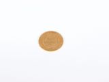 a gold coin sitting on top of a white surface