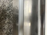 a metal elevator with a glass door in the middle of the room