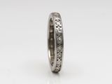 a close up of a wedding ring with diamonds on a white background