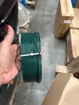 une personne tenant une bobine de fil vert à la main