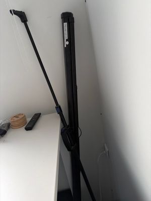 un trépied noir posé sur un bureau blanc, près d'un mur blanc