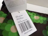 a label on the back of a green and black dress