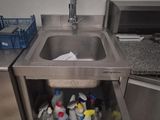 a stainless steel sink in the corner of a kitchen