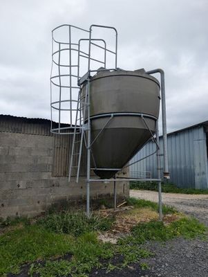 un grand réservoir métallique placé sur le côté d'un bâtiment