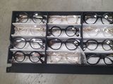 many pairs of glasses sitting in a display case