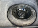 a tire in the trunk of a car with a flat tire