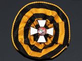 yellow, black and white badge with a cross in the center