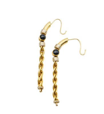 a pair of gold earrings with black stones on them