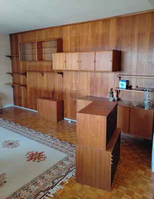 une pièce équipée d'un bureau, d'étagères et d'un tapis