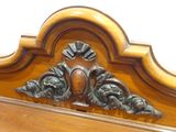 a wooden headboard with a carved design on top of it