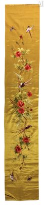 une soie jaune ornée de fleurs rouges et d'oiseaux, accrochée au mur