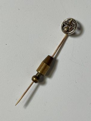 a small metal object with a wooden handle on a white surface