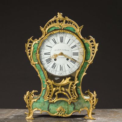 a green and gold clock sitting on a table
