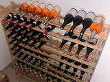many bottles of wine on a wooden rack in a room