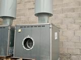 two industrial air conditioners sitting on the side of a building