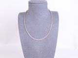 a necklace on a mannequin display with a white background