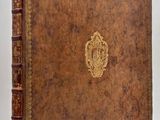 an old leather book with a gold emblem on the cover