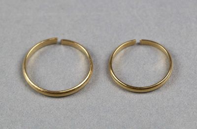 deux boucles d'oreilles en anneau dorées sur un fond blanc