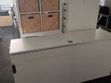 a white desk with drawers in the middle of a room