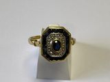 une image représentant une bague en or sertie d'une pierre noire et blanche